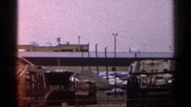 1966: a busy freeway overpass with parked vehicles and two trucks driving by
