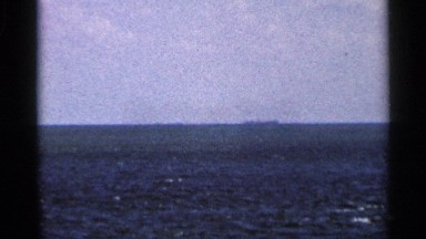 1966: a distance boat captured on a clear day it's sailing in middle of sea