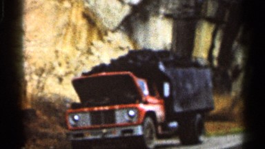 1966: a truck loaded with goods are parked in side of a road