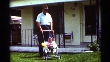 1963: older man, possibly grandfather, watches over a child in a stroller