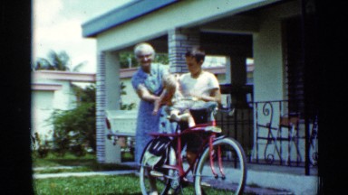 1963: boy watching a baby sitting in the cycle where his grandma left the place