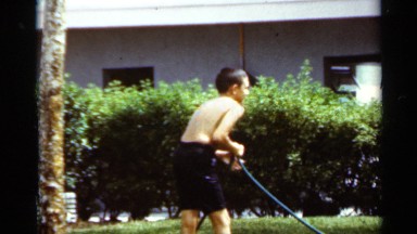 1963: some children playing with a hose while watering the garden MISSISSIPPI