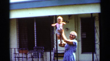 1963: mother holding her baby above her head and playing