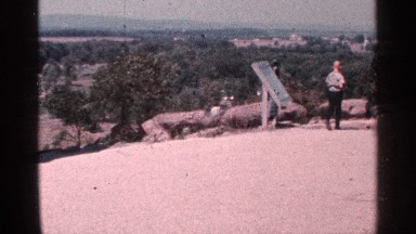 1964: person walking past a plaque on top of a mountain. PENNSYLVANIA