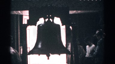 1964: people stand around viewing a large bell with their hands