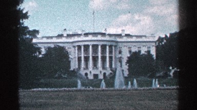 1964: a palace with a flag at the top and a fountain