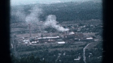 1964: long shot view of a small bustling town with smoking industries