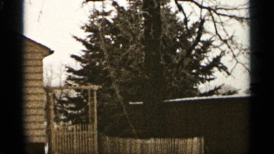 1965: a building with trees at the morning in the sky clouds and a gate