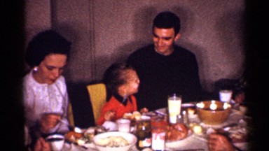 1958: the family sit in the chair near to food table, vintage clip