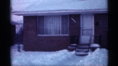 1958: building near to huge snow ice and car near and street fully ice snow
