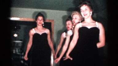1958: women dance in the black dress hand is shaking back side wall photo light