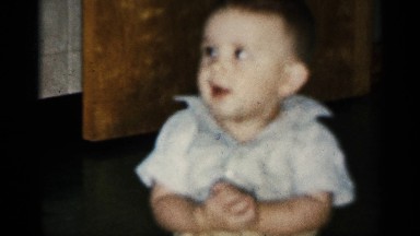 1958: a smiling baby plays with his hands. NEW JERSEY