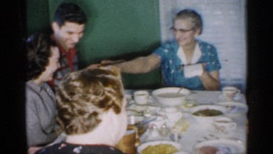 1958: a lady passes napkins to her family members as they eat a meal. NEW JERSEY