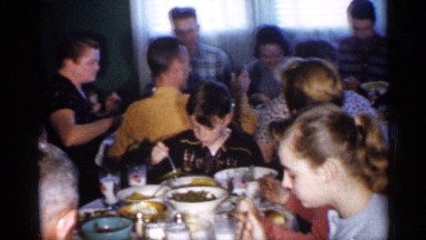 1958: a group of peoples sit and eat the food its look like a hotel or party