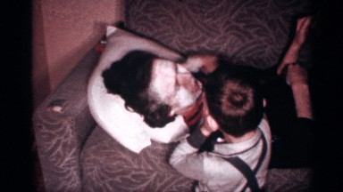 1958: a lady with her kid at home and the kid applied powder on her face