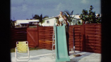 1963: Child Sliding on Yellow Slide in Mississippi Backyard