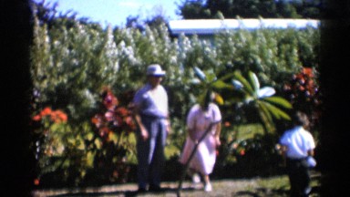 1958: a small boy and grand mother father still of the small size tree