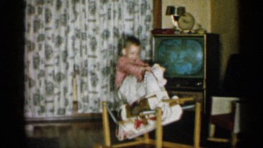 1959: child rocking back and forth on his toy horse rocking chair