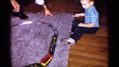 1959: a small boy watch the doll train go to the track round shape move control