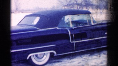 1959: a person get ready to start up the car and leafs are falling in the car