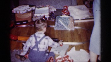 1959: a small kid play with his toy train at his house and his mother working