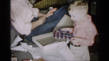 1959: young boy is surprised to receive a striped shirt as a present from family
