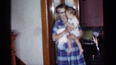 1955: grandmother holding blonde baby while a man descends the stairs NEW YORK