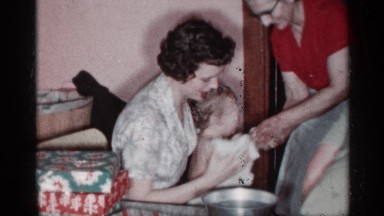 1955: a group of three ladies use a pan of water to bathe a baby NEW YORK