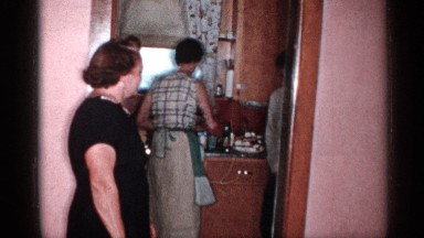 1955: woman standing in a kitchen doorway watching two men act silly. NEW YORK