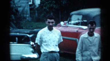 1955: two men walk near some vintage automobiles NEW YORK