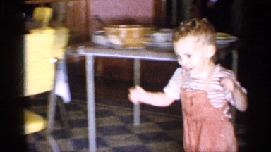 1955: a young boy runs to the opposite side of room to meet older man NEW YORK