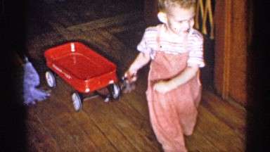1955: home interior, showing youngster, pulling toy across floor. NEW YORK