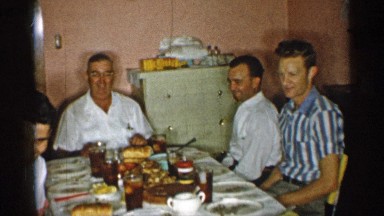 1955: family gathered around table and having food NEW YORK