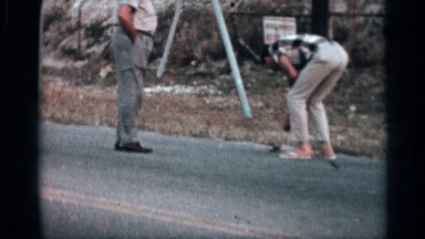 1958: a man taking an insect at the road it looks like railway track