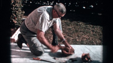1958: a man take the coconut use for tools near walk place and house green