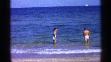 1958: a child and two adults enjoy walking in the water. FLORIDA