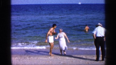 1958: couple enjoys the beach , while man watches the ocean from afar. FLORIDA