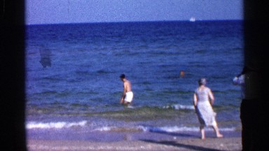 1958: the beach side bath the men and children in the ocean morning