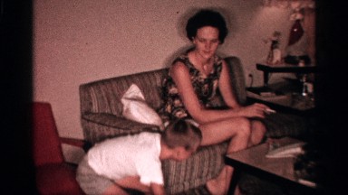 1958: a small boy in the dance in our house near to our mother sit in