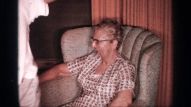1958: happy boy dances for the camera while grandparents watch and laugh about