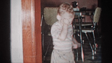 1955: a toddler walks across a room and then back again looking at camera
