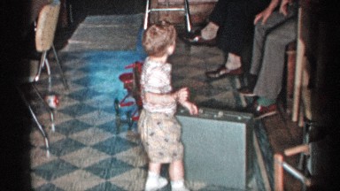 1955: a boy kid at his house taking a suitcase and push down the suitcase