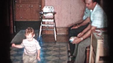 1955: a man gives the small ball to his son causing the little boy to bounce it