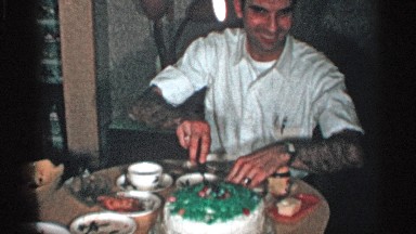 1955: a man cutting a slice of birthday cake as his mom looks on NEW YORK