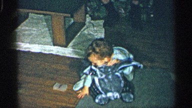 1955: child plays with stuffed bunny on living room floor NEW YORK