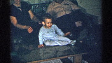 1955: baby sitting on a table, playing with grandparents NEW YORK
