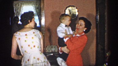 1955: grandmother happily holds baby while mom excuses herself from the room