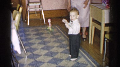 1955: little boy picking up dropped toy NEW YORK