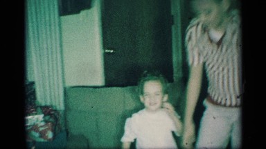 1959: boy child is shows his happiness by jumping on seeing elder christmas gift