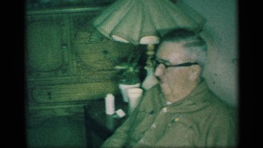 1959: grandfather sitting down in a living room watch his granddaughter
